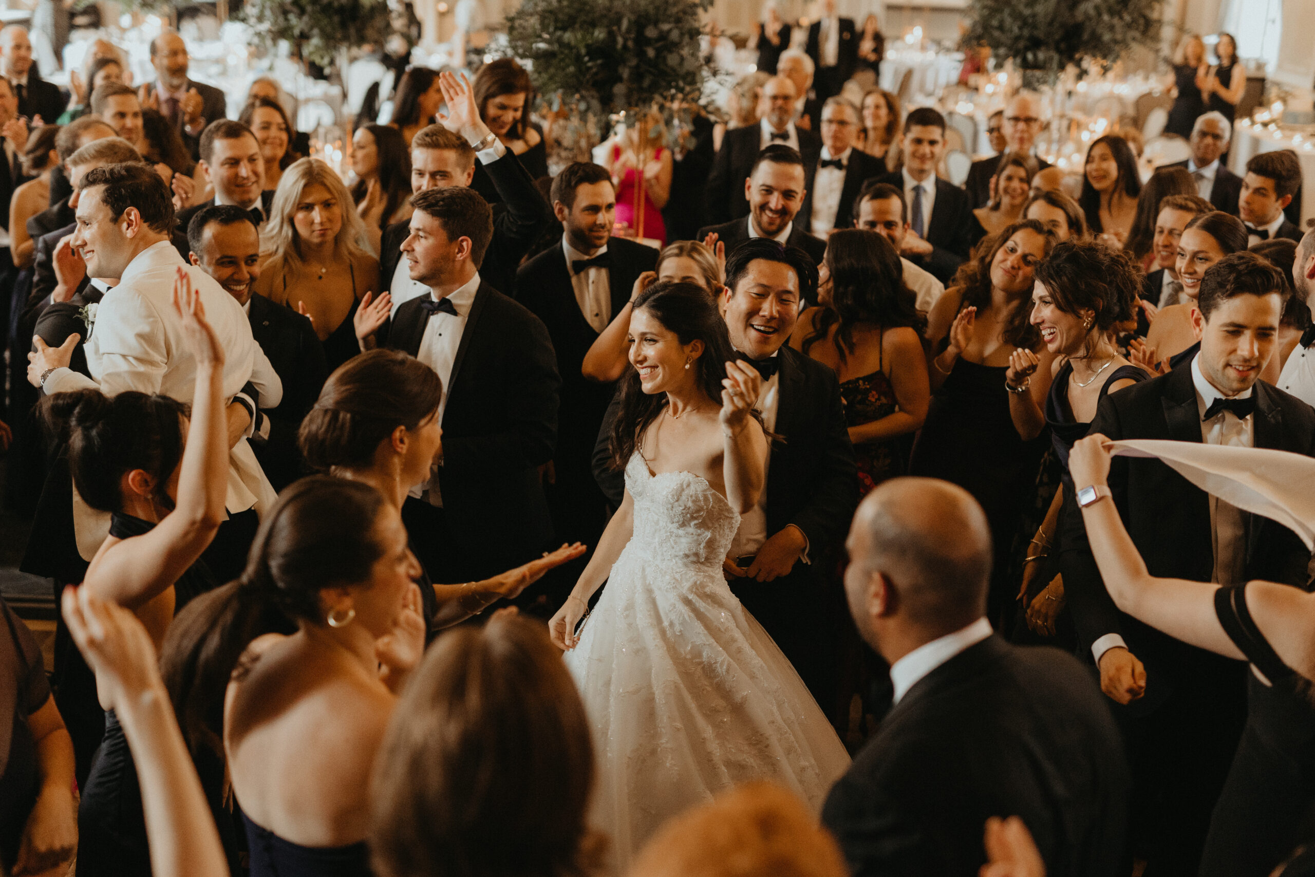 A bride dancing surrounded by her guests.