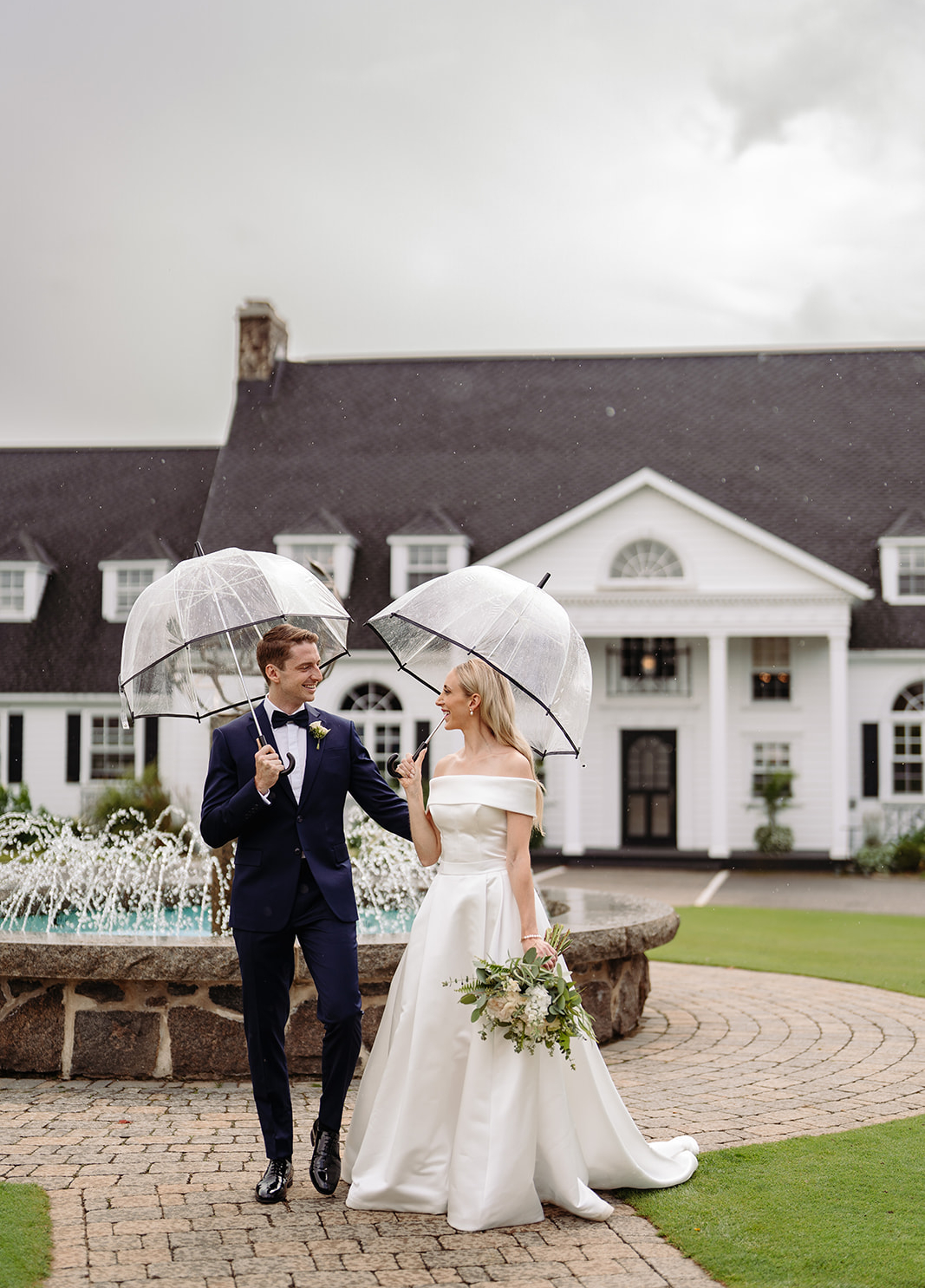 A couple standing in front of a stunning venue in Quebec City, symbolizing a $65K luxury wedding planned by Emmanuelle Weddings.