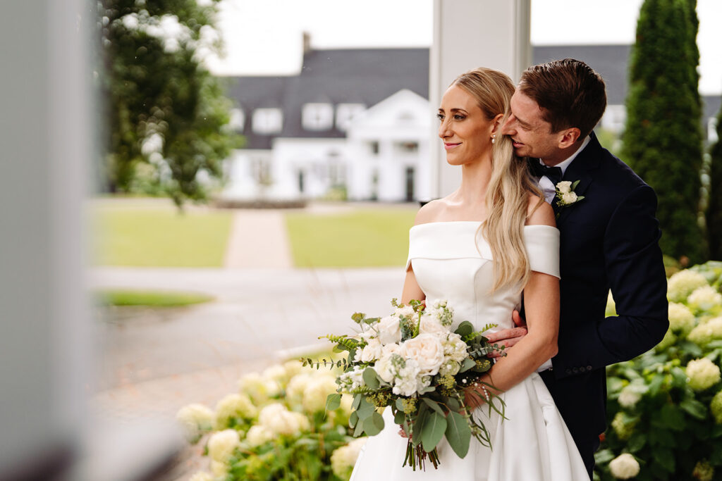 Are you dreaming of a wedding in Quebec City that embodies luxury and sophistication yet fits in a budget of CA $65,000? Admire this beautiful couple posing in front of the stunning venue, showcasing the bride's exquisite beauty, hair, and makeup.