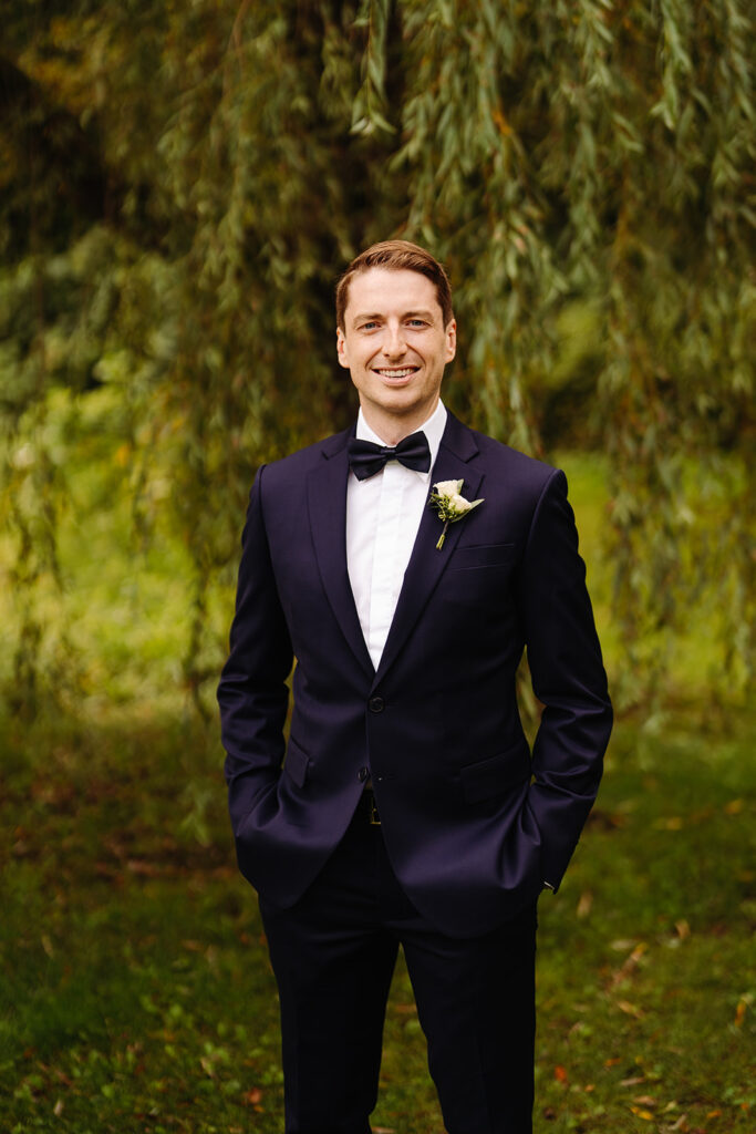 Boutonnière délicate portée par le marié à Québec, conçue par Élysée Fleurs pour Emmanuelle Weddings, symbolisant l'élégance et l'attention aux détails.