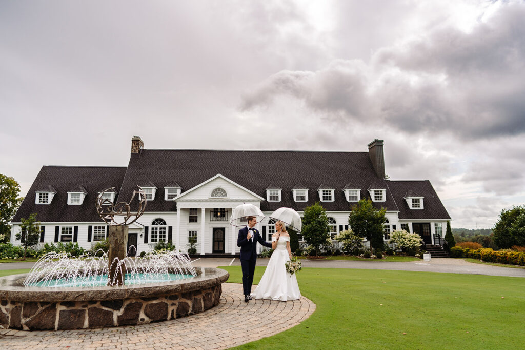 Un couple devant un imposant immeuble sur un terrain de golf à Québec, illustrant un cadre romantique planifié par Emmanuelle Weddings.