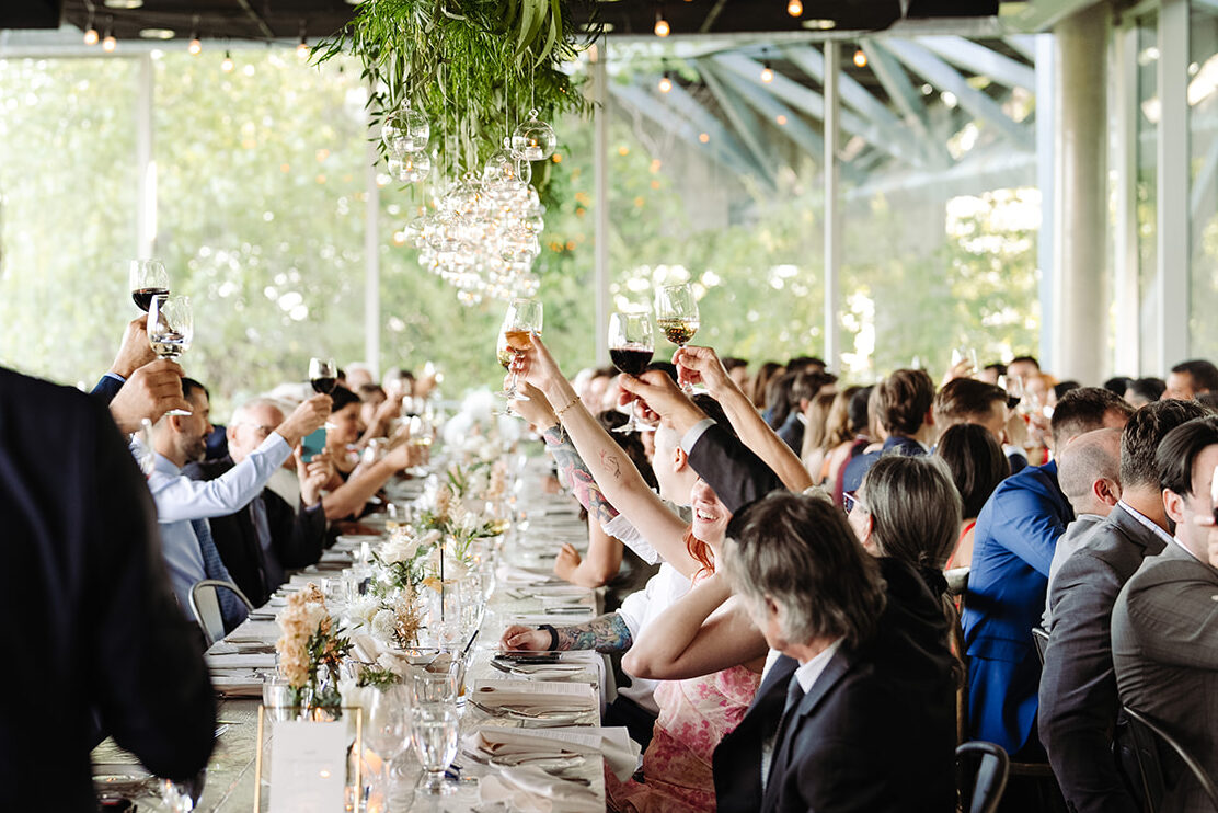 Guests toasting to the newlyweds, capturing the joyful celebration as friends and family raise their glasses in honor of the couple's special day.