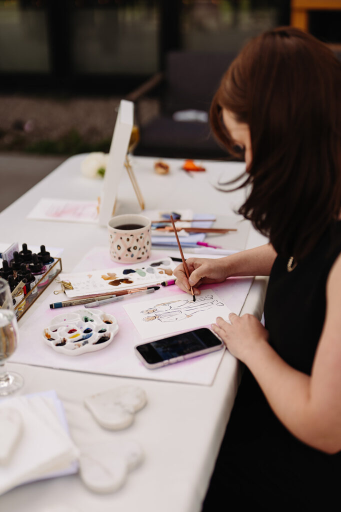 A live sketching vendor performing at a wedding, capturing detailed moments of the event while guests observe the artistic process.