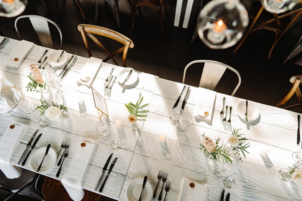 A simple and elegant wedding table setup showcasing a clean design with delicate floral arrangements, and refined tableware for a sophisticated event.